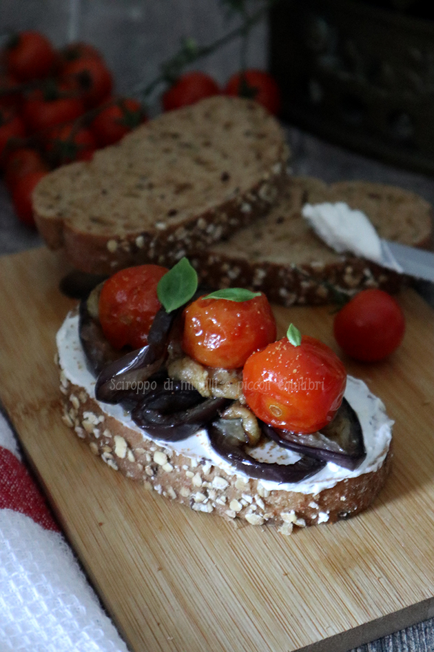 Bruschetta di pane di semi vari con ricotta, melanzane, pomodorini caramellati e polvere di bottarga
