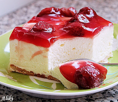 Naš Top 5 kolač svih vremena: Čizkejk krem sa jagodama - Mamina jela Čizkejk krem sa podlogom od plazma keksa, bogatim filom od krem sira i prelivom od crvenog voća na belom tanjiru.