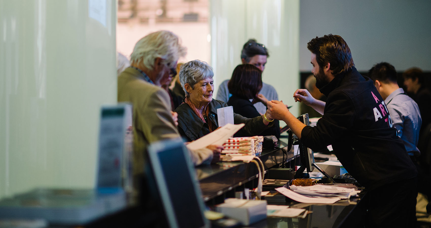 <p>Gallery visitors being welcomed at the information desk on the Ground level</p>