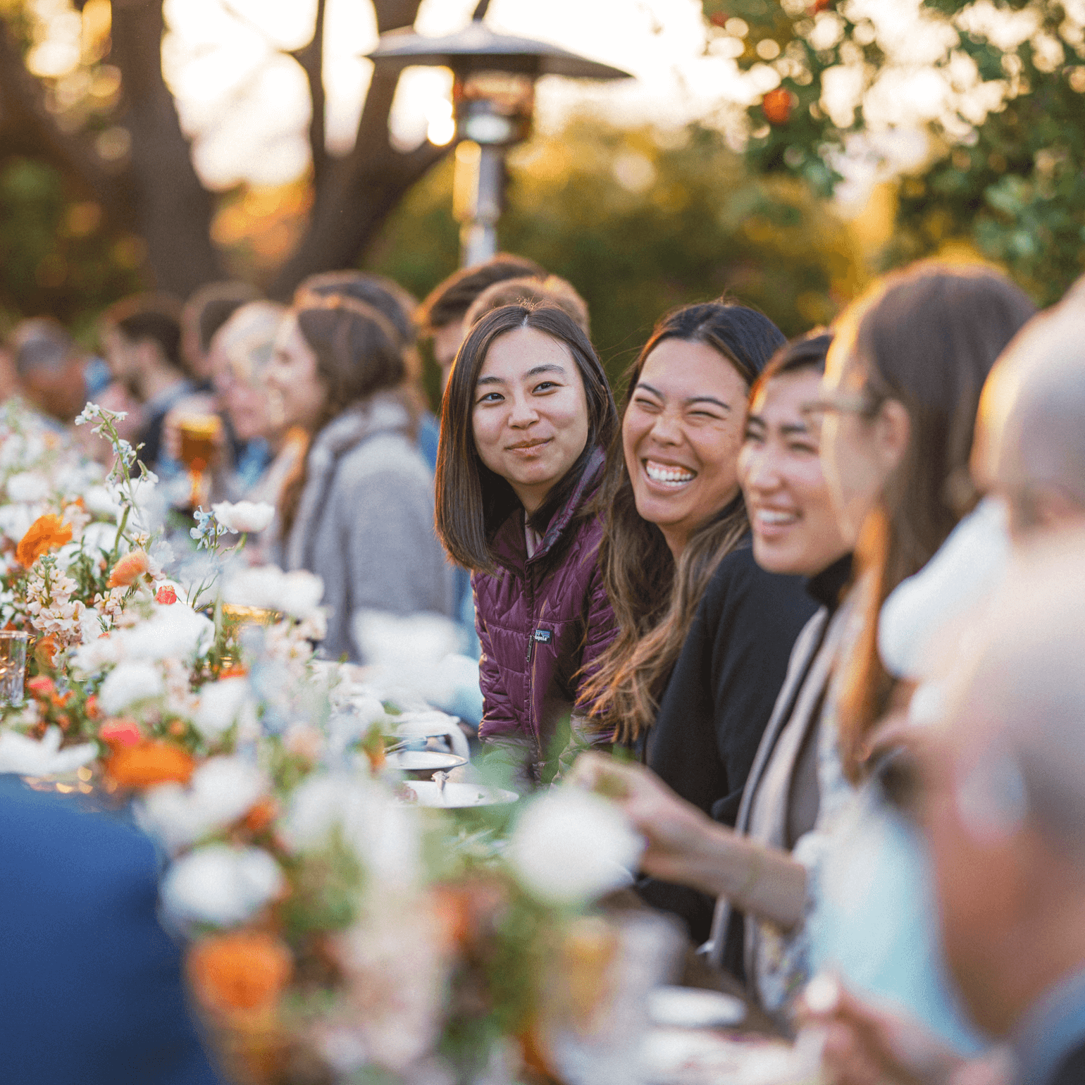 Guests enjoy a golden-hour celebration in Southern California, surrounded by elegant florals and warm conversation. A joyful outdoor gathering beautifully catered by Chef Joann.