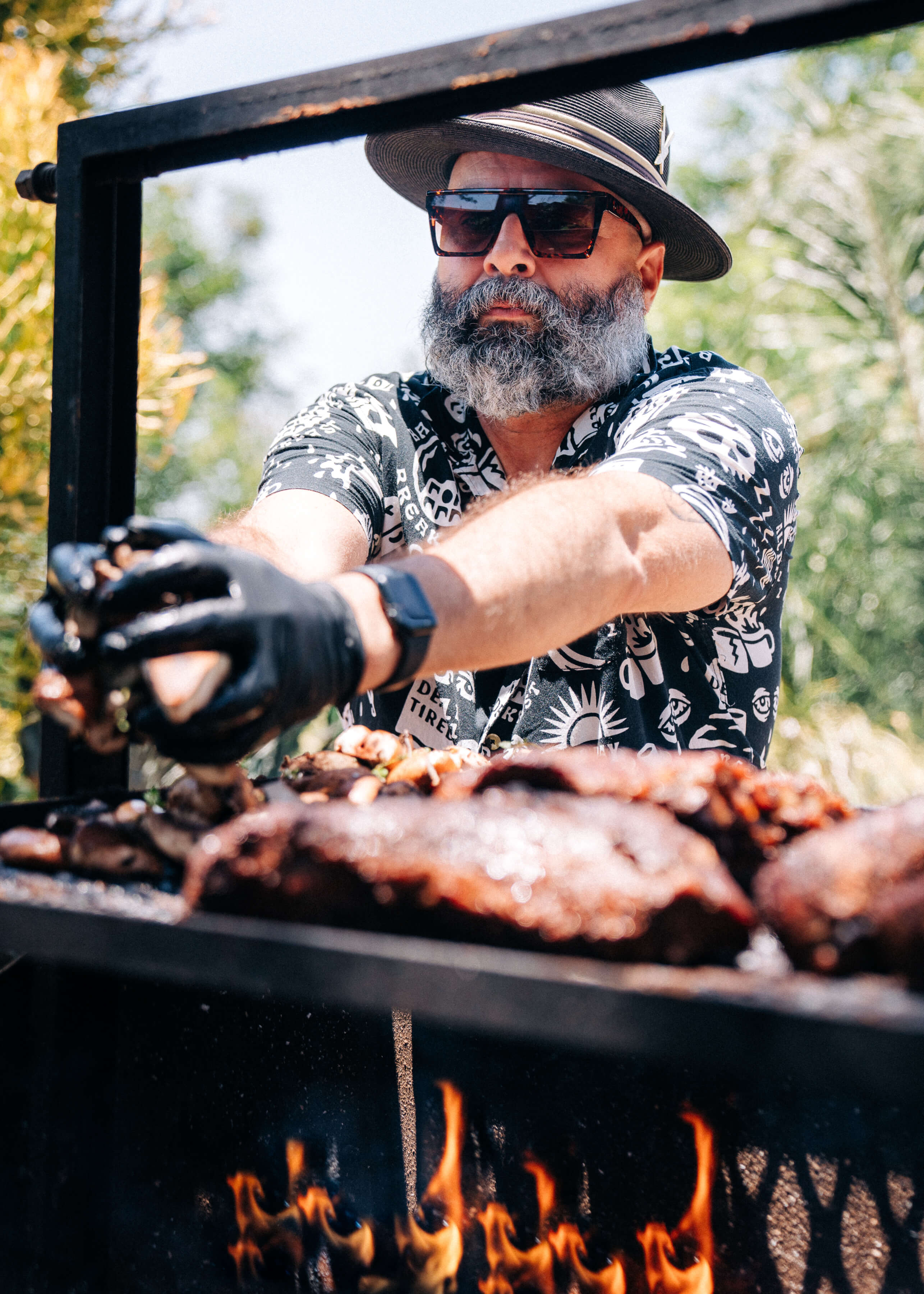 Close-up of Chef Josh preparing barbecue at a Chef Joann Catering event, focusing on grilling technique and smoky flavors