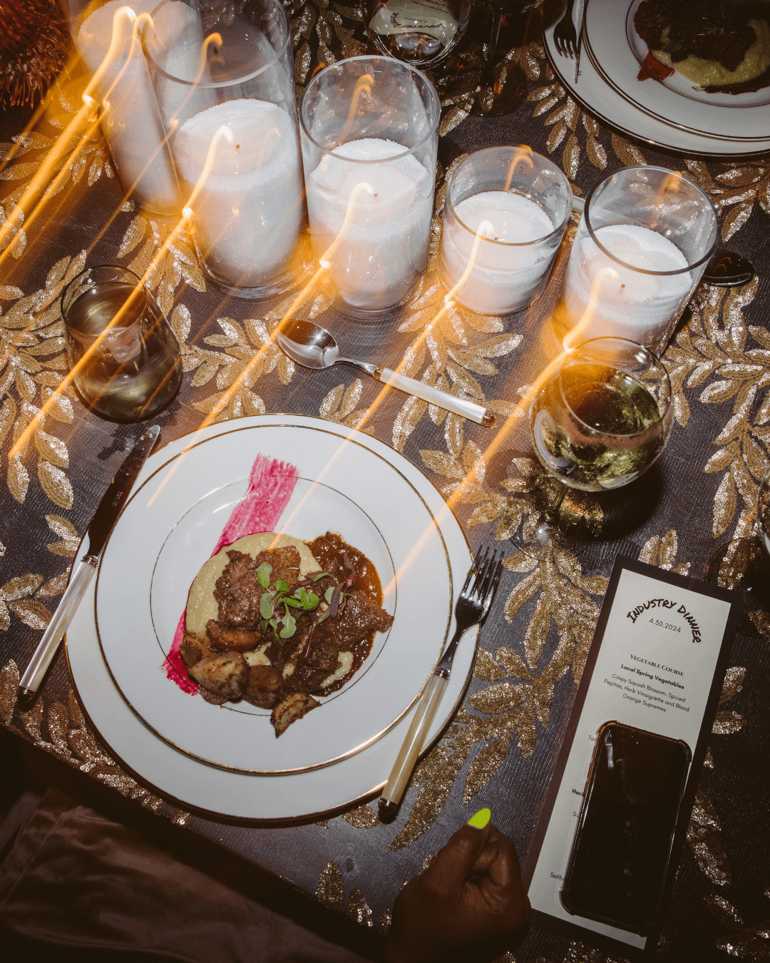 Close-up of Chef Joann Catering's Doors-inspired dish with artful plating, accompanied by 5-6 glass candle votives, created for a Los Angeles industry dinner celebrating the band's mystique.