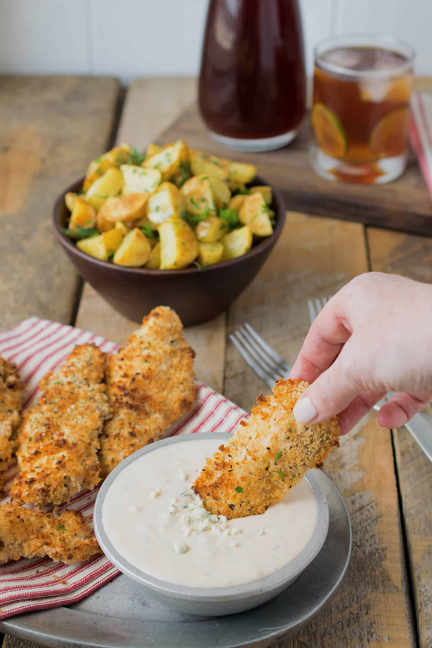 Dipping a breaded chicken tender into blue cheese sauce