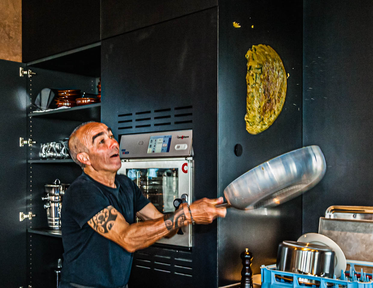 Flying Frittata. Den Halbmond aus Eiern mit Kratern aus wildem Spargel wendet Giulio in der Luft. / © Foto: Georg Berg