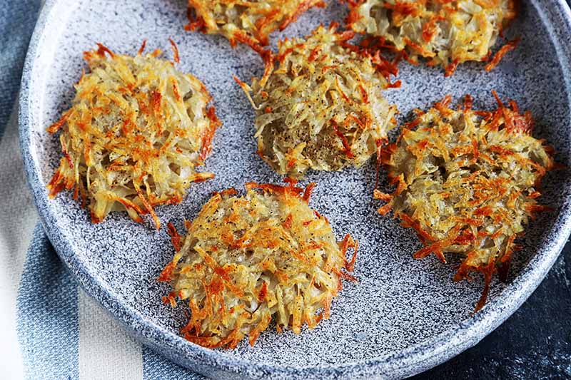 Horizontal image of cooked potato pancakes on a gray plate.