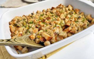 Horizontal image of a white casserole dish filled with a bread stuffing.