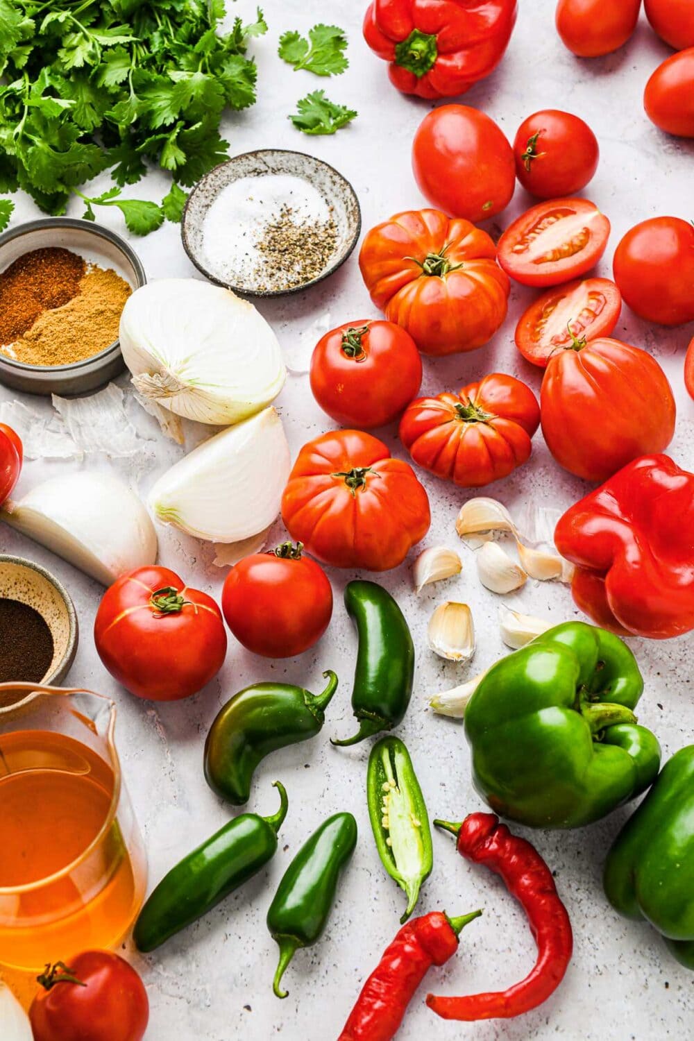 ingredients for canning salsa, with tomatoes, garlic, peppers, onions