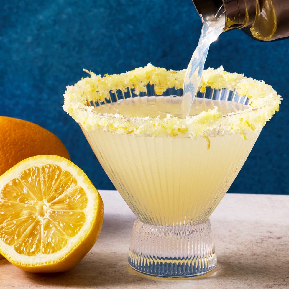 Lemon drop martini in clear, stemless martini glass with a sugar and lemon zest rim and lemon twist Lemon drop martini in clear, stemless martini glass with a sugar and lemon zest rim and lemon twist