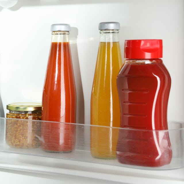 Bottles with different tasty sauces and products in fridge, closeup Bottles with different tasty sauces and products in fridge, closeup