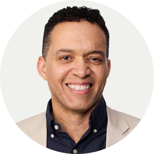 Circular headshot with obscured facial features.