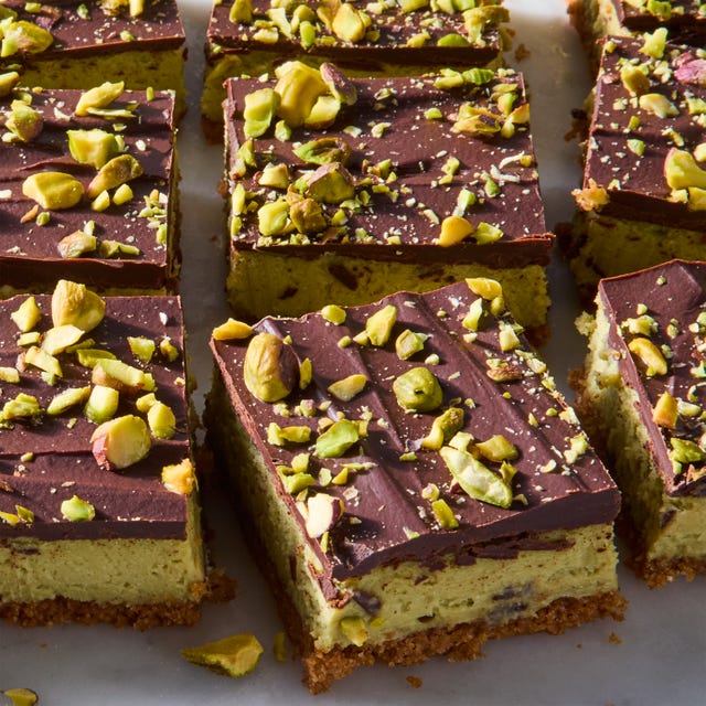 pistachio cheesecake bars topped with chocolate and chopped pistachios
