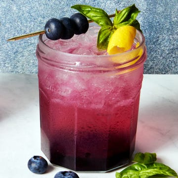 Blueberry Jam Gin Spritz gin spritz in a jam jar garnished with a lemon twist and blueberries