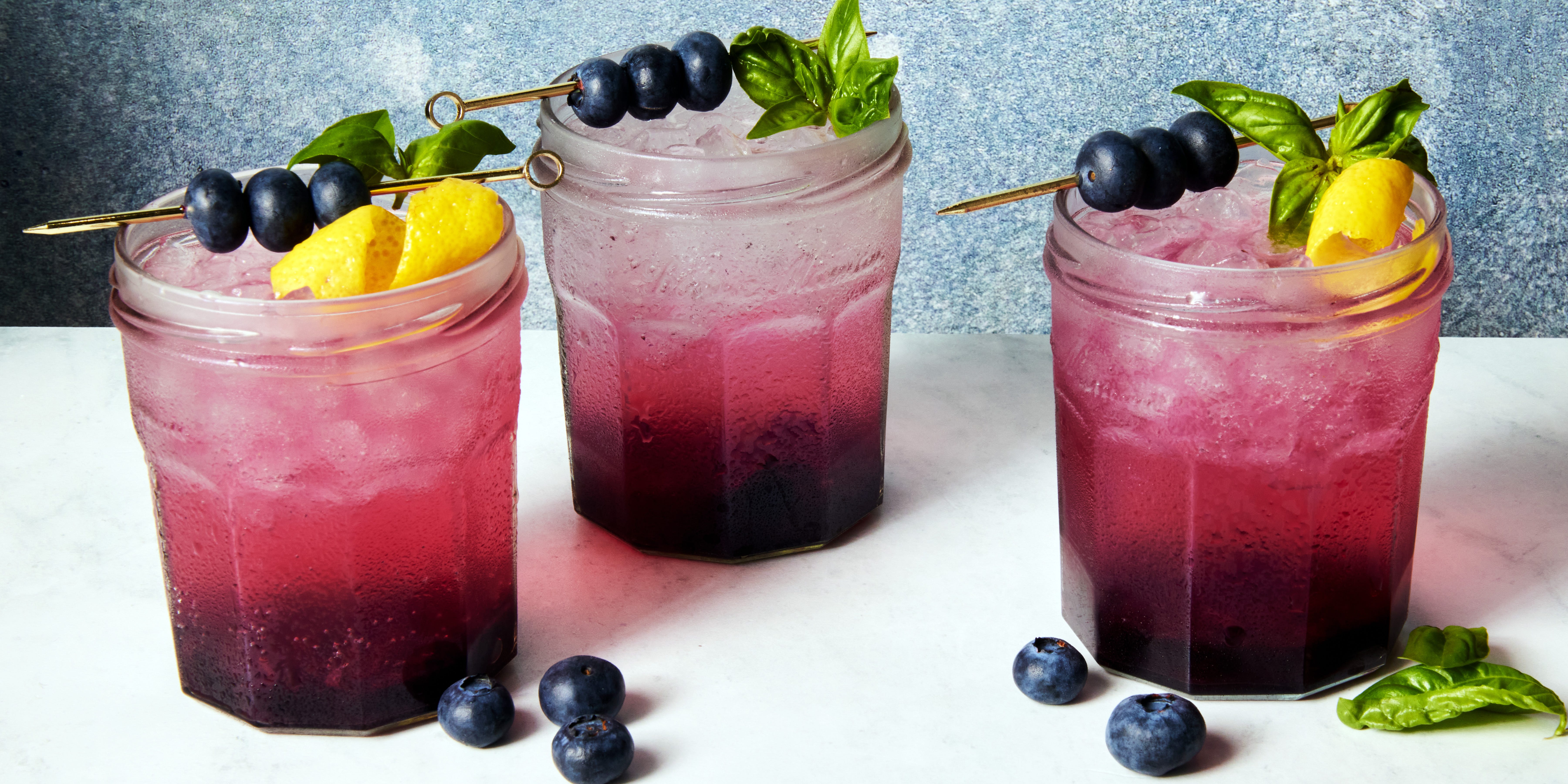 Blueberry Jam Gin Spritz gin spritz in a jam jar garnished with a lemon twist and blueberries