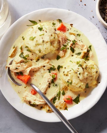 shredded chicken and dumplings and carrots in a creamy broth, topped with chopped parsley