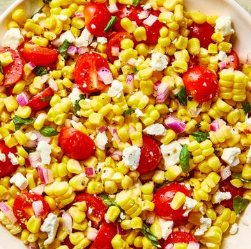 Corn Salad corn, chopped tomatoes, feta and basil in a bowl