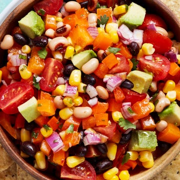 Cowboy Caviar beans, tomatoes, red onion, and avocado in a bowl with chips