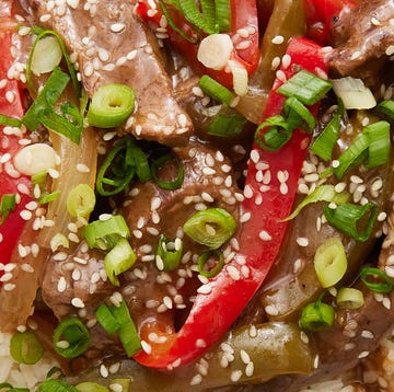 Crockpot Pepper Steak strips of flank steak with green and red peppers in a sauce served over white rice
