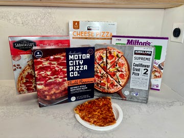 Assorted frozen pizza boxes with a slice on a plate.