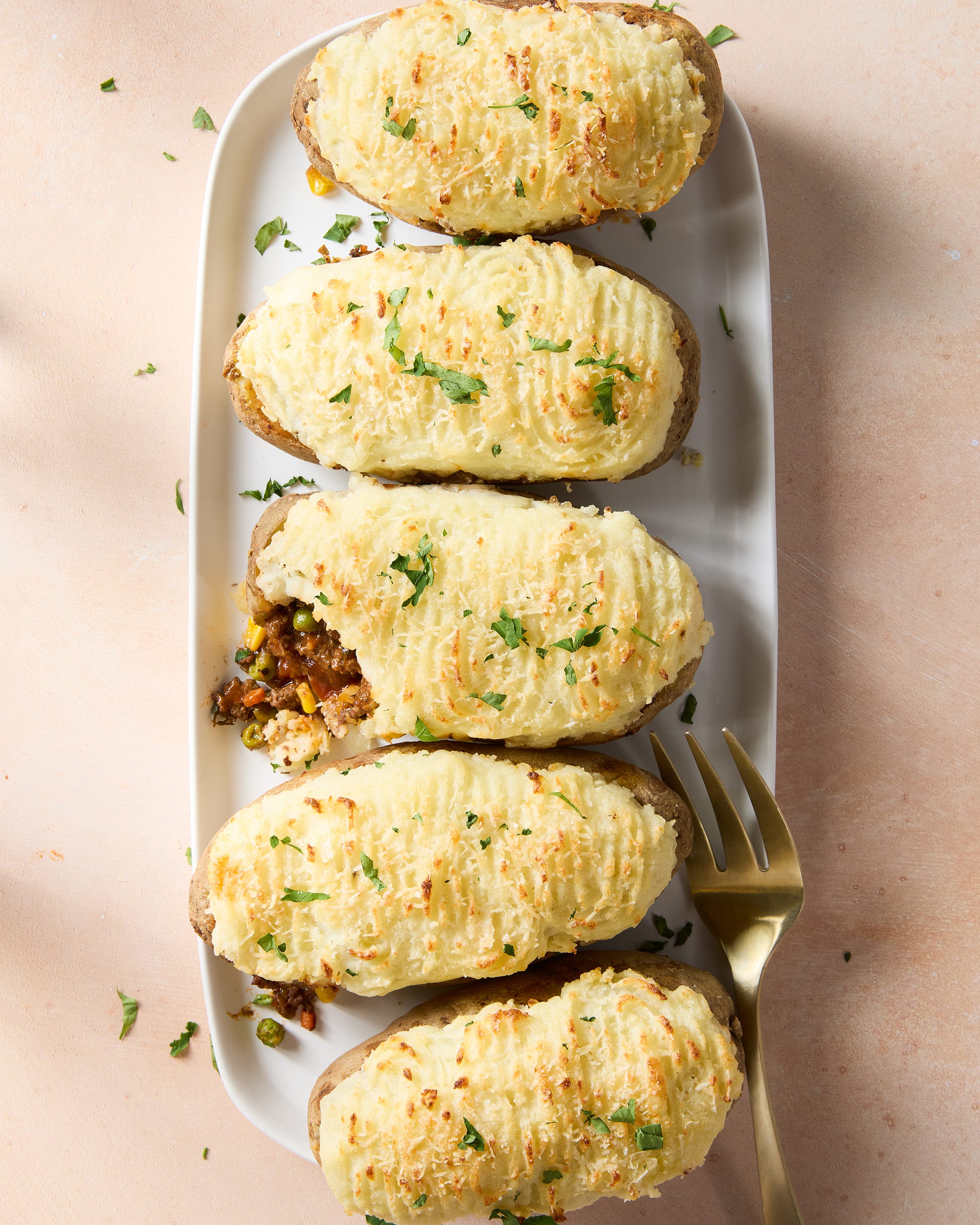 a saucy, red wine spiked ground beef and vegetable mixture gets loaded into hollowed out russet potatoes, topped with parmesan mashed potatoes, and baked until golden brown