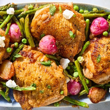 One-Pan crispy chicken primavera crispy chicken thighs with roasted radishes, asparagus, and peas on a white platter