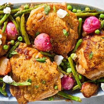 One-Pan crispy chicken primavera crispy chicken thighs with roasted radishes, asparagus, and peas on a white platter