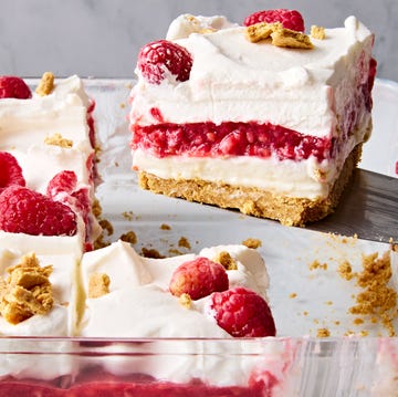 Raspberry cheesecake lasagna a slice of no bake raspberry cheesecake lasagna lifting out of the larger cheesecake lasagna in a glass pan