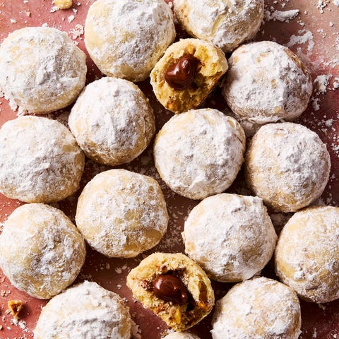 Nutella Stuffed Snowball Cookies round hazelnut shortbread cookies coated in powdered sugar with nutella in the center of each cookie