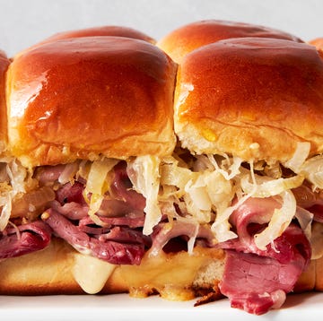 Corned Beef Sliders a tray of sliders made with hawaiian rolls, corned beef, sauerkraut, and swiss cheese