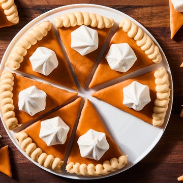Pumpkin Pie Sugar Cookies triangular spiced shortbread cookies coated in orange icing, beige frosting, and a vanilla meringue cookie