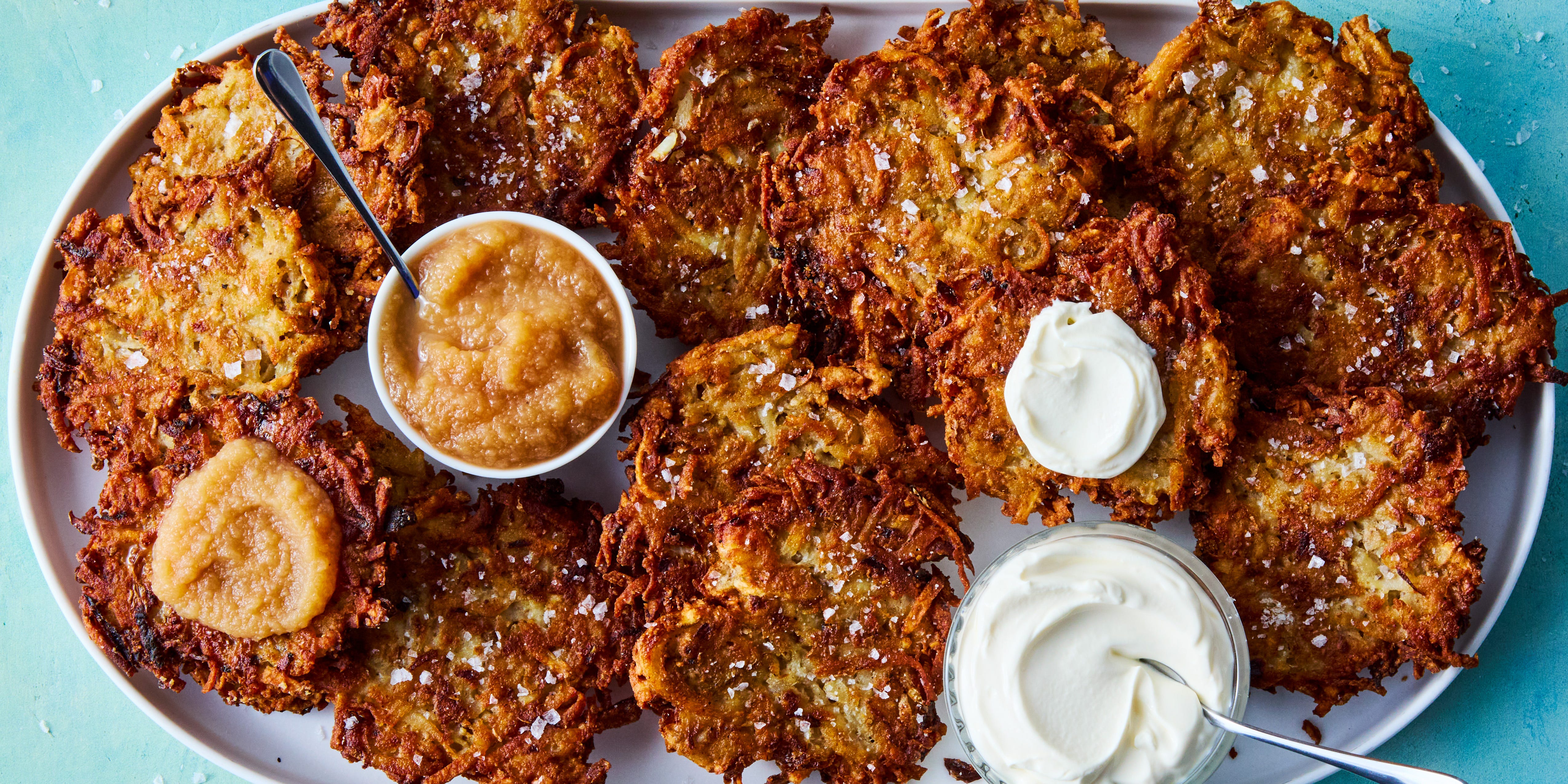 Latkes crispy latkes on a platter with bowls of sour cream and applesauce