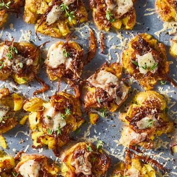French onion smashed potatoes french onion smashed potatoes topped with caramelized onions, gruyere, and thyme on a baking sheet