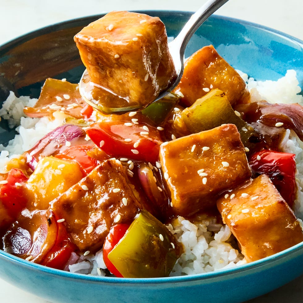 Sweet and Sour tofu a pan of crispy tofu cubes with red onion, bell peppers, pineapple, and a sweet and sour sauce