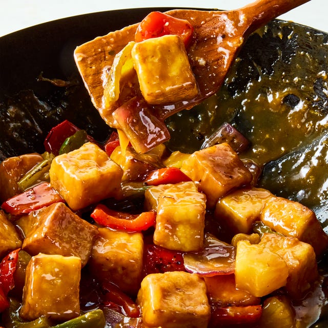 Sweet and Sour tofu a pan of crispy tofu cubes with red onion, bell peppers, pineapple, and a sweet and sour sauce
