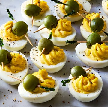 Dirty Martini Deviled Eggs deviled eggs decorated to look like dirty martinis with olives on a toothpick