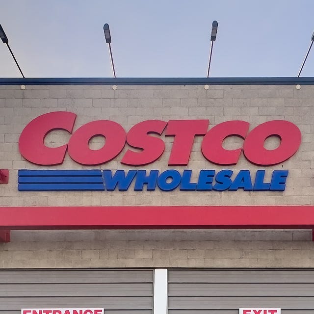 Exterior shot of a Costco Wholesale store at dusk with Costco Wholesale signage and people entering, exiting. Shopping carts visible calgary, alberta, canada. apr 10, 2025. exterior shot of a costco wholesale store at dusk with "costco wholesale" signage and people entering, exiting. shopping carts visible