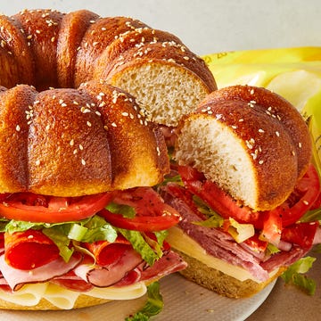 Giant Party Sub bundt cake bread filled with sliced salami, ham, provolone, tomatoes, lettuce, and pepperoni