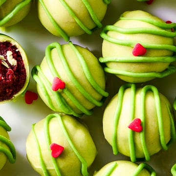 Grinchy Christmas Cake Bites green covered cake bites with red hearts