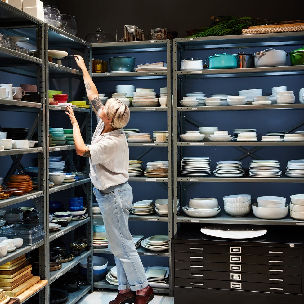 woman talking plates off the shelves