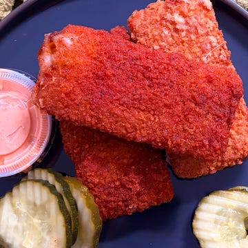 plate of crispy fried chicken pieces with pickles and dipping sauce plate of crispy fried chicken pieces with pickles and dipping sauce