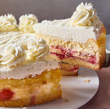 Copycat Lemon-Raspberry Cream Cheesecake cake and cheesecake layers topped with lemon mousse, cheesecake, and raspberry syrup