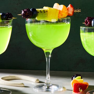 Luck-Tini green cocktail with a skewered rainbow fruit garnish