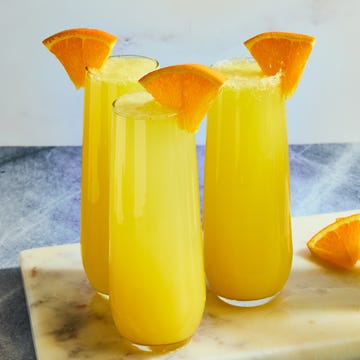 Mimosas orange juice and champagne in a flute garnished with an orange wedge