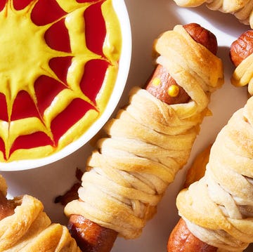 Mummy Hot Dogs hot dogs with mustard eyes wrapped in crescent dough with cheese and served a mustard and ketchup dip