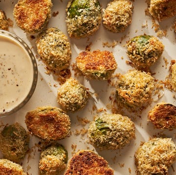 Parmesan Crusted Brussels Sprouts parmesan crusted brussels sprouts on a sheet pan next to a ramekin of caesar dressing