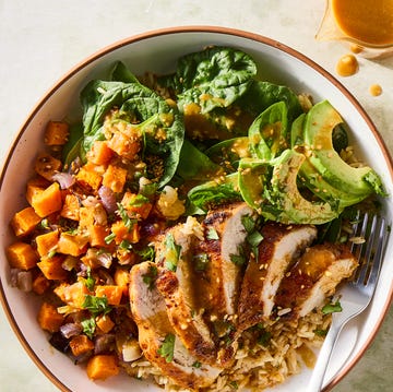 Peanut Chicken Protein Bowl sliced chicken in a grain bowl with sweet potatoes, avocados, spinach and a peanut dressing