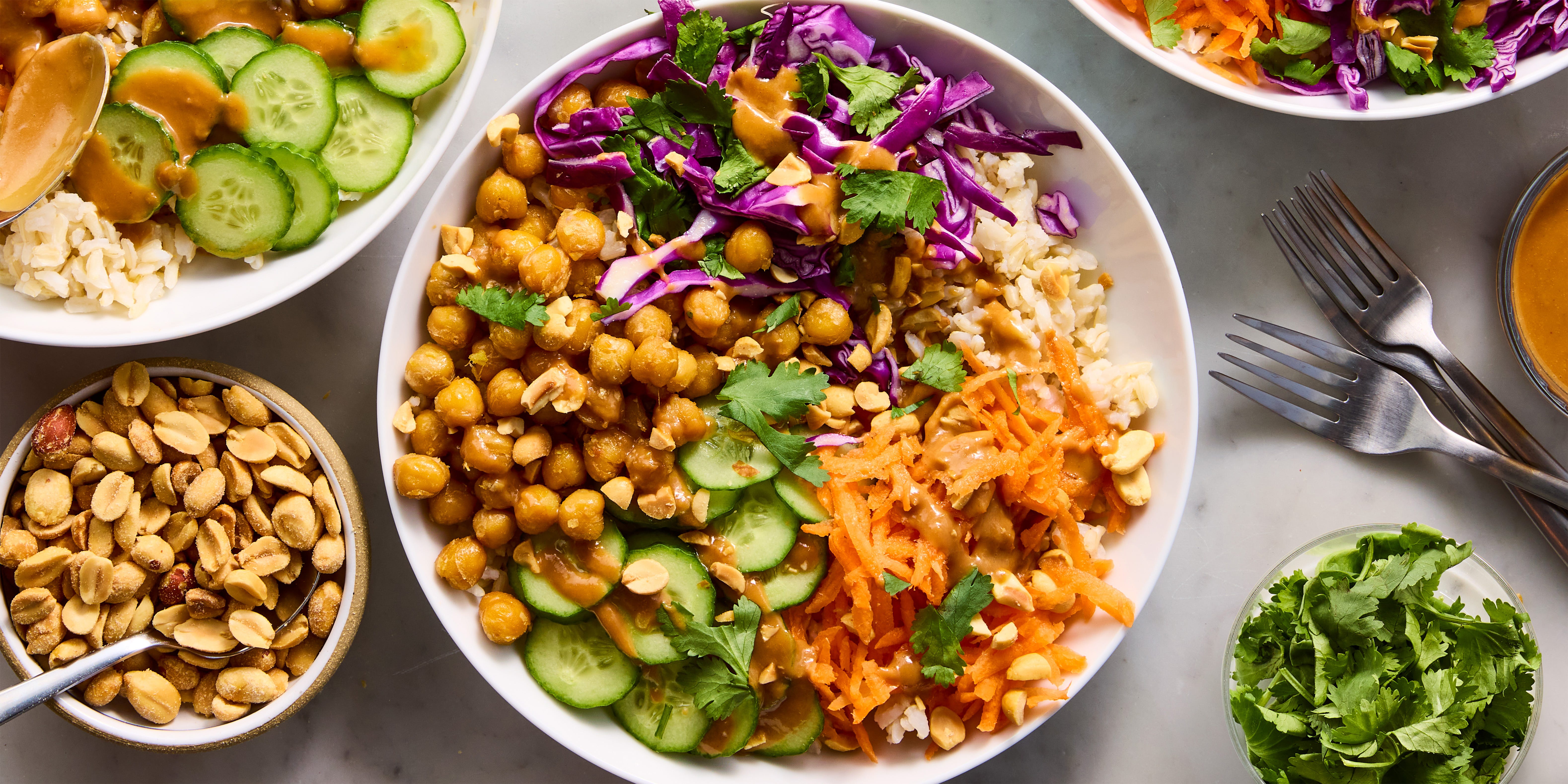 Peanut Chickpea Protein bowls peanut chickpea protein bowls with rice, crispy chickpeas, red cabbage, carrot, cucumbers, and peanut sauce