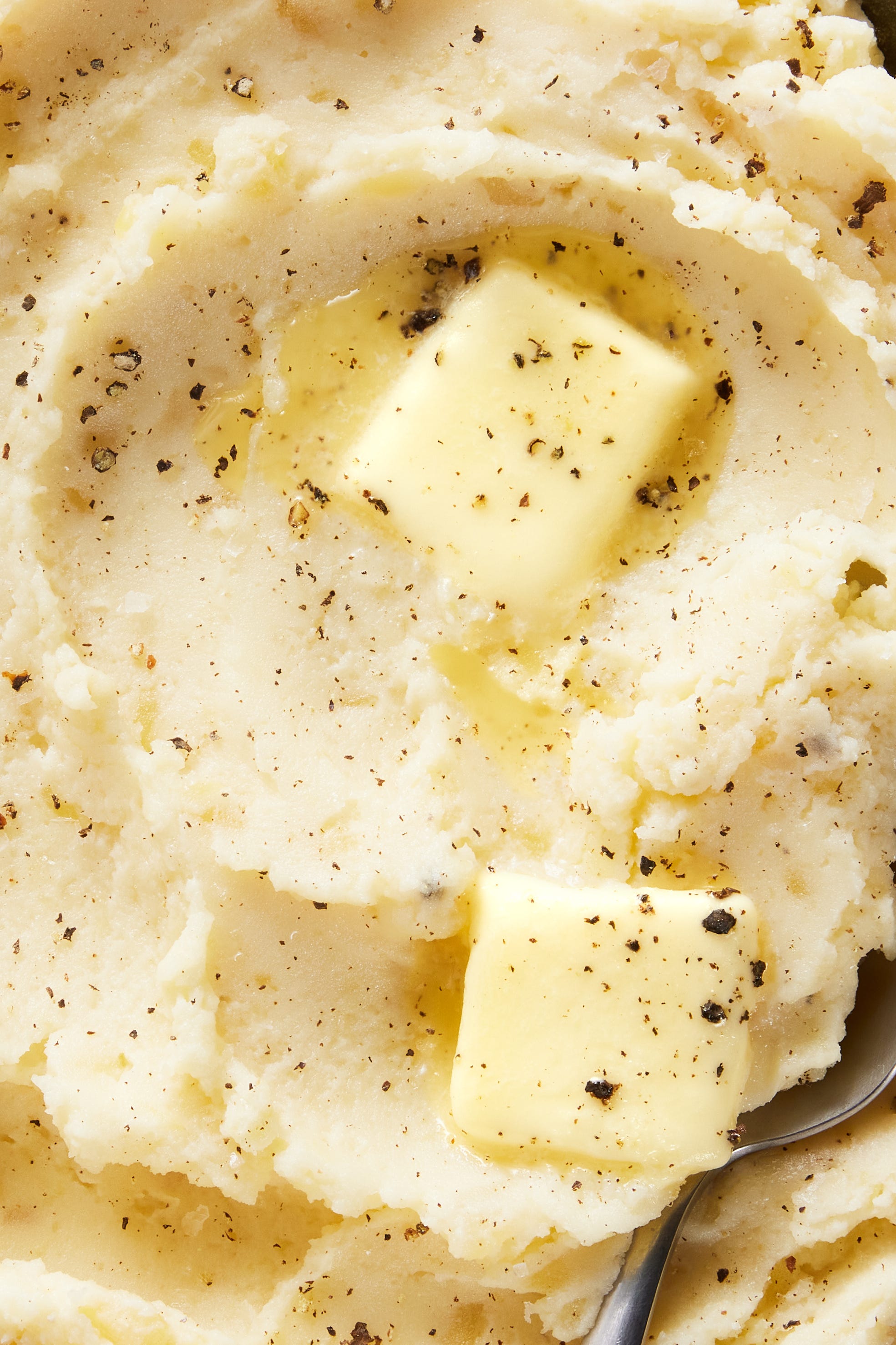 Slow-Cooker Mashed Potatoes slow cooker mashed potatoes with a pat of butter, salt, and pepper