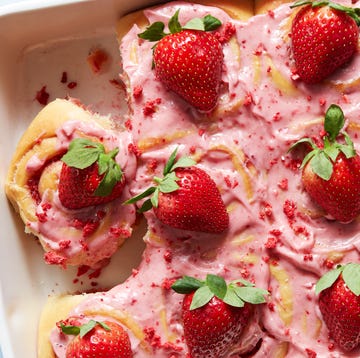 Strawberry Crunch Cinnamon Rolls cinnamon rolls topped with strawberry frosting, crunch pieces, and strawberries