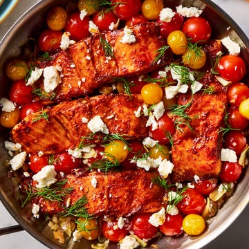 Summer Salmon Skillet salmon filets are dusted with cumin and paprika, rubbed with spicy harissa paste, and roasted alongside cherry tomatoes, shallots, and garlic, then topped with fresh dill and creamy feta
