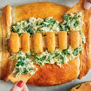 Super Bowl Bread Dip spinach and artichoke dip in a bread bowl shaped like a football